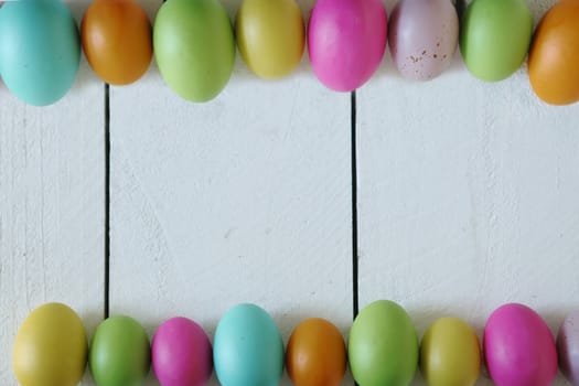 Spring or Easter Themed Background of Old Wood and Colored Eggs Lined Up