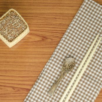 brown kitchen towel with spoon on wood background