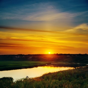 last sunrays in sky over river