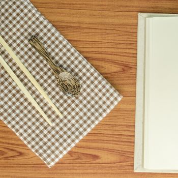 brown kitchen towel with spoon on wood background