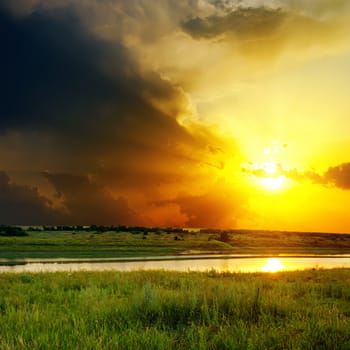 dramatic orange sunset over river