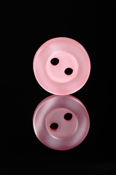 a pink button isolated in black