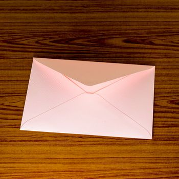 soft pink envelope on wooden background