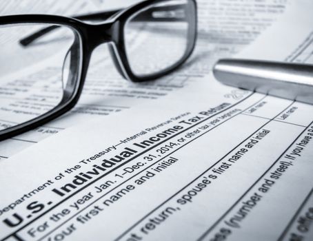 Detail Of A 2014 Tax Return With Glasses And Pen (With Shallow DoF)