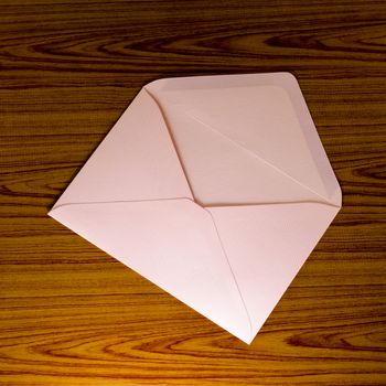soft pink envelope on wooden background