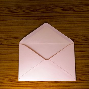 soft pink envelope on wooden background