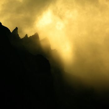 Clouds dramatically glowing over a mountain ridge