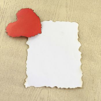 heart and white paper on wood background