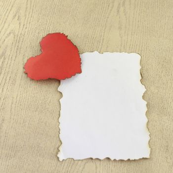 heart and white paper on wood background