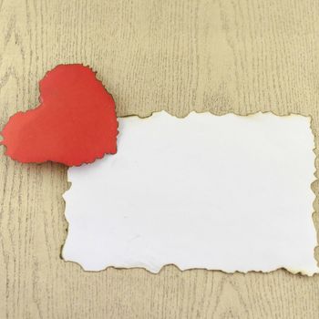 heart and white paper on wood background