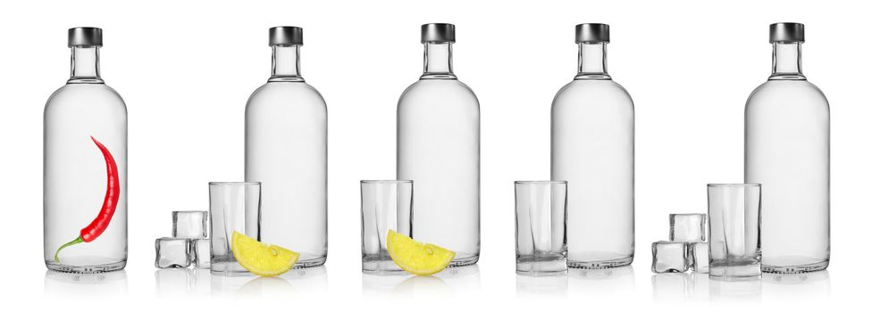 Bottles of vodka and glasses isolated on white