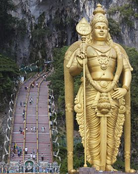 BATU CAVES, MALAYSIA - FEB 5, 2014: Lord Murugan Hindu Deity Statue by Hindu Temple Entrance at Batu Caves in Malaysia. A popular tourist attraction north of Kuala Lumpur.