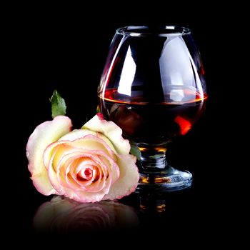 Glass and rose. Alcohol and flower. Glass with drink and a pink rose.
