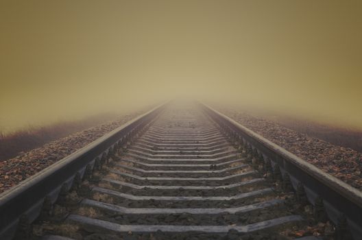 grunge railroad to horizon in fog