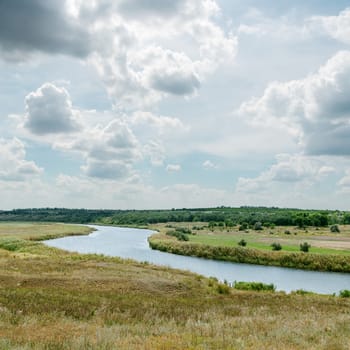 dramatic sky over green landscape with river