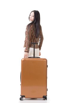 Modern Asian woman stand with a luggage, full length portrait on white background.