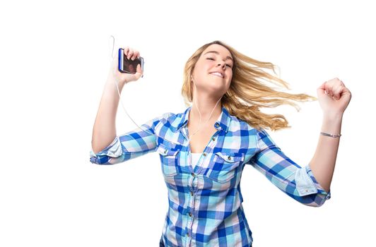 Portrait of beautiful blonde teenager listening music and dancing with a smartphone on white background