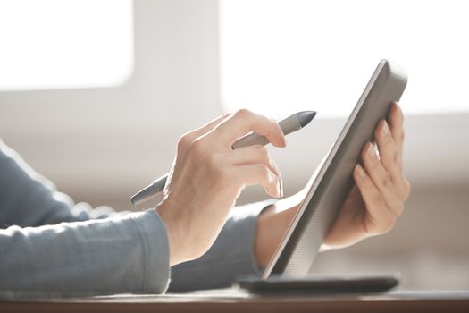 Hands of designer working with tablet PC and stylus