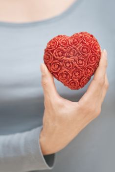 Woman hand holding heart as a symbol of love