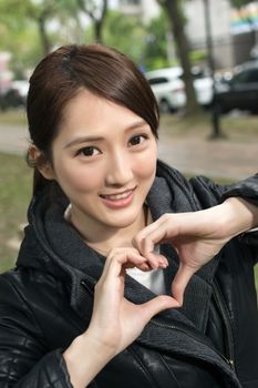 Asian young woman give you a gesture heart shape, close up portrait.