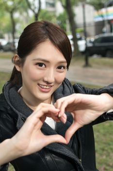 Asian young woman give you a gesture heart shape, close up portrait.