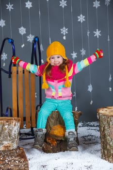 Winter Fashion. Adorable happy fashion girl in winter hat gloves and sweater in studio.