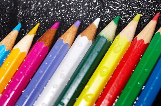 Row of wet colorful crayon. Close-up view