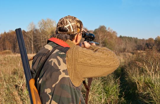 Hunter aiming with telescope sights on rifle