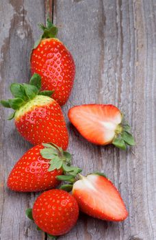 Ripe Strawberries Full Body In a Row and Halves isolated on Wooden background. Top View