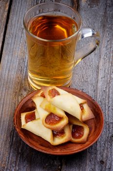 Cup of Black Tea and Cookies with Jam Wrapped isolated on Rustic Wooden background