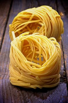 Two Nests of Raw Vermicelli isolated on Rustic Wooden background