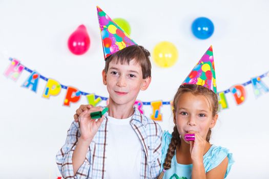 Cute girl and boy having fun at birthday party