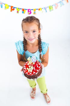 Pretty beautiful girl with birthday cake on birthday party.