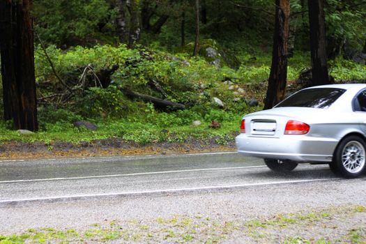 Automobile driving on the puddle on a highway