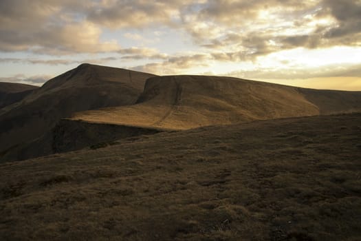 Mountain peaks in the autumn evening sky with clouds