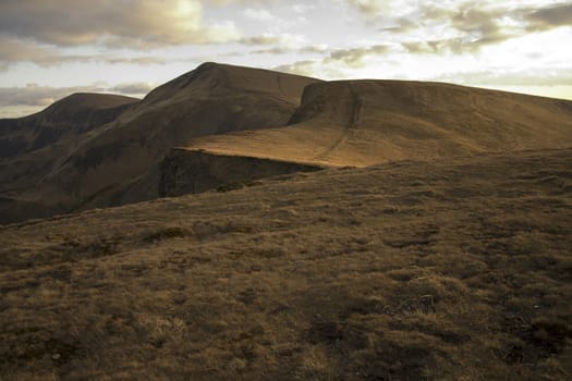 Mountain peaks in the autumn evening sky with clouds