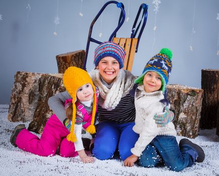 Winter Fashion. Adorable happy boy and girls in winter hat gloves and sweater in studio.