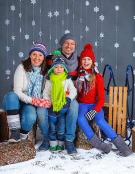 Winter Fashion. Happy family in winter hat gloves and sweater in studio.