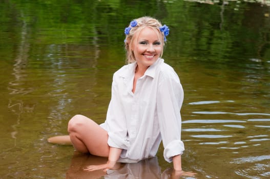 Shot of female in a white shirt sitting in water