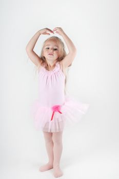 Studio shot of little ballet dancer girl doing pas