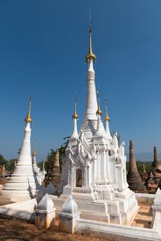 White ancient Burmese Buddhist pagodas Nyaung Ohak in the village of Indein on Inlay Lake in Shan State, Myanmar (Burma).