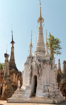 White ancient Burmese Buddhist pagodas Nyaung Ohak in the village of Indein on Inlay Lake in Shan State, Myanmar (Burma).