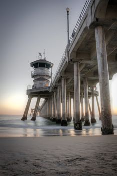 Long exposure captures slow moving waves under The Huntington Beah Pier in Huntington Beach, California