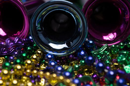 Mardi Gras celebration.  Purple Mardi Gras horns on top of colorful beaded background