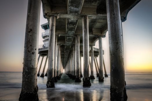 Long exposure captures slow moving waves under The Huntington Beah Pier in Huntington Beach, California