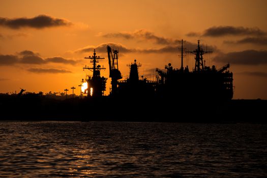 USNS Bridge Sealift Command's Fast Combat Support Ship. Docked in San Diego Bay in  silhouette at sunset