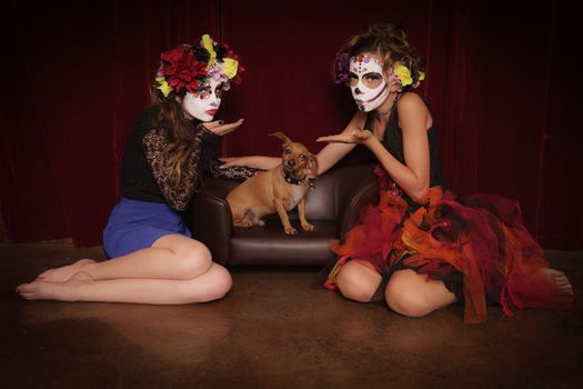 Day of The Dead girls in costume and make up blowing kisses to Chiweenie dog