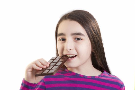 Little girl eating chocolate on white background