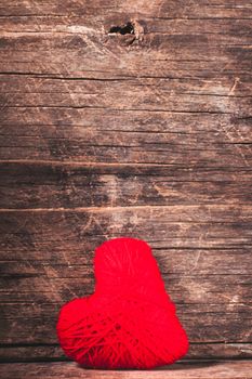 Red thread heart over old shabby background. Valentine concept