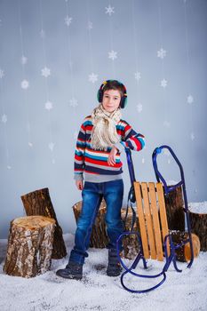 Winter Fashion. Adorable happy fashion boy in winter hat gloves and sweater in studio.